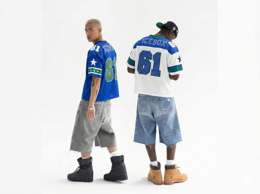 Two people wearing sports jerseys and shorts on a white background