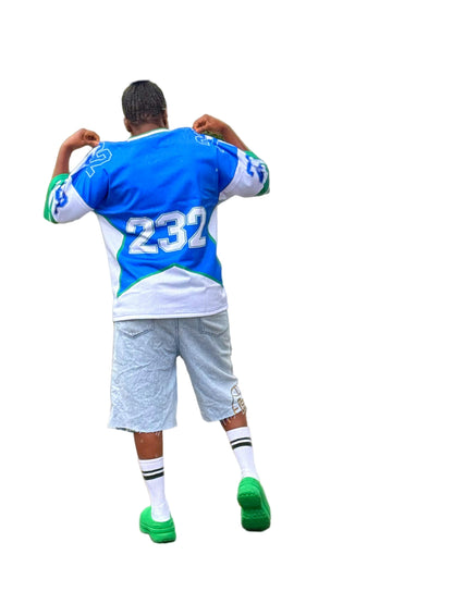 Person wearing a blue and white sports jersey with the number 232, standing outdoors with a car in the background.