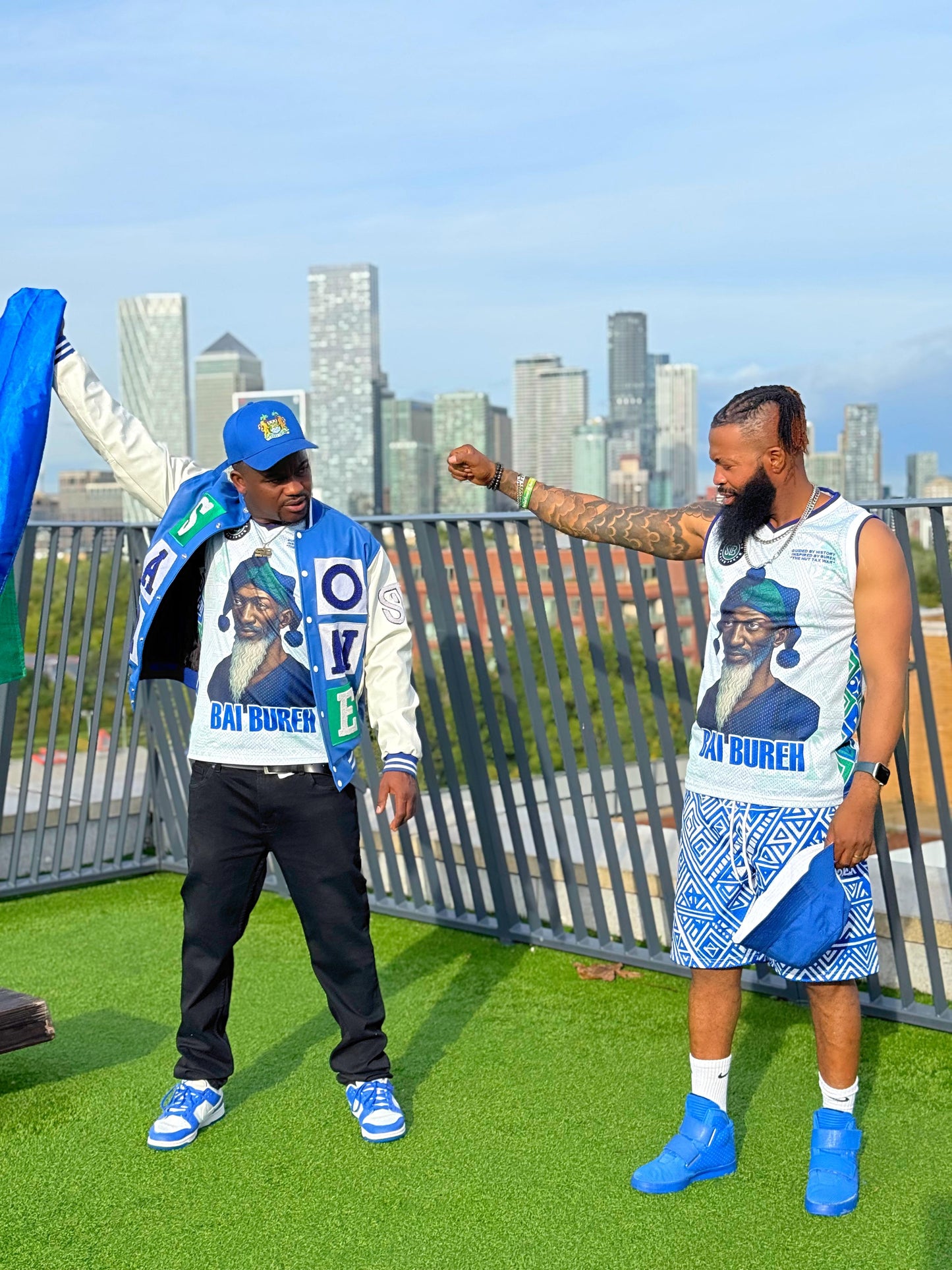 Two people in matching outfits with a city skyline in the background