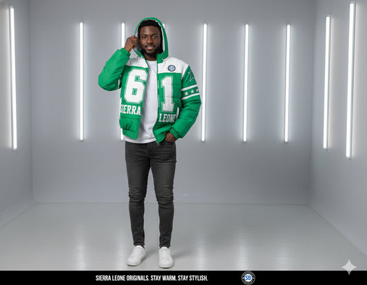 Person wearing a green and white jacket with text, standing in a minimalistic room with white walls and lights.
