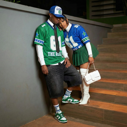 Two people in coordinated outfits with sports-themed clothing on a staircase.
