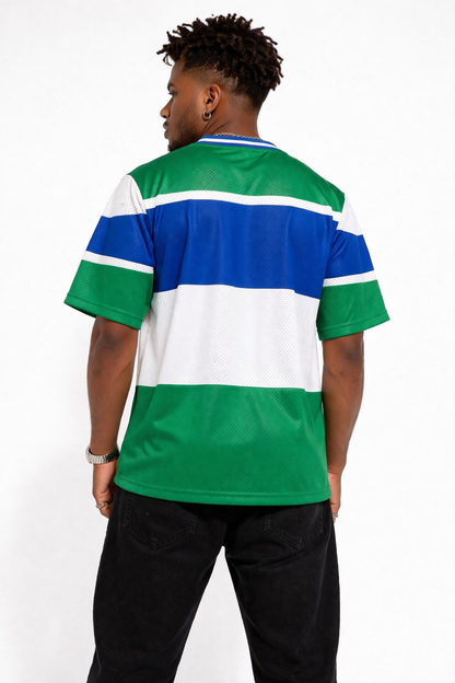 Back view of a model wearing a green, white, and blue striped shirt on a white background