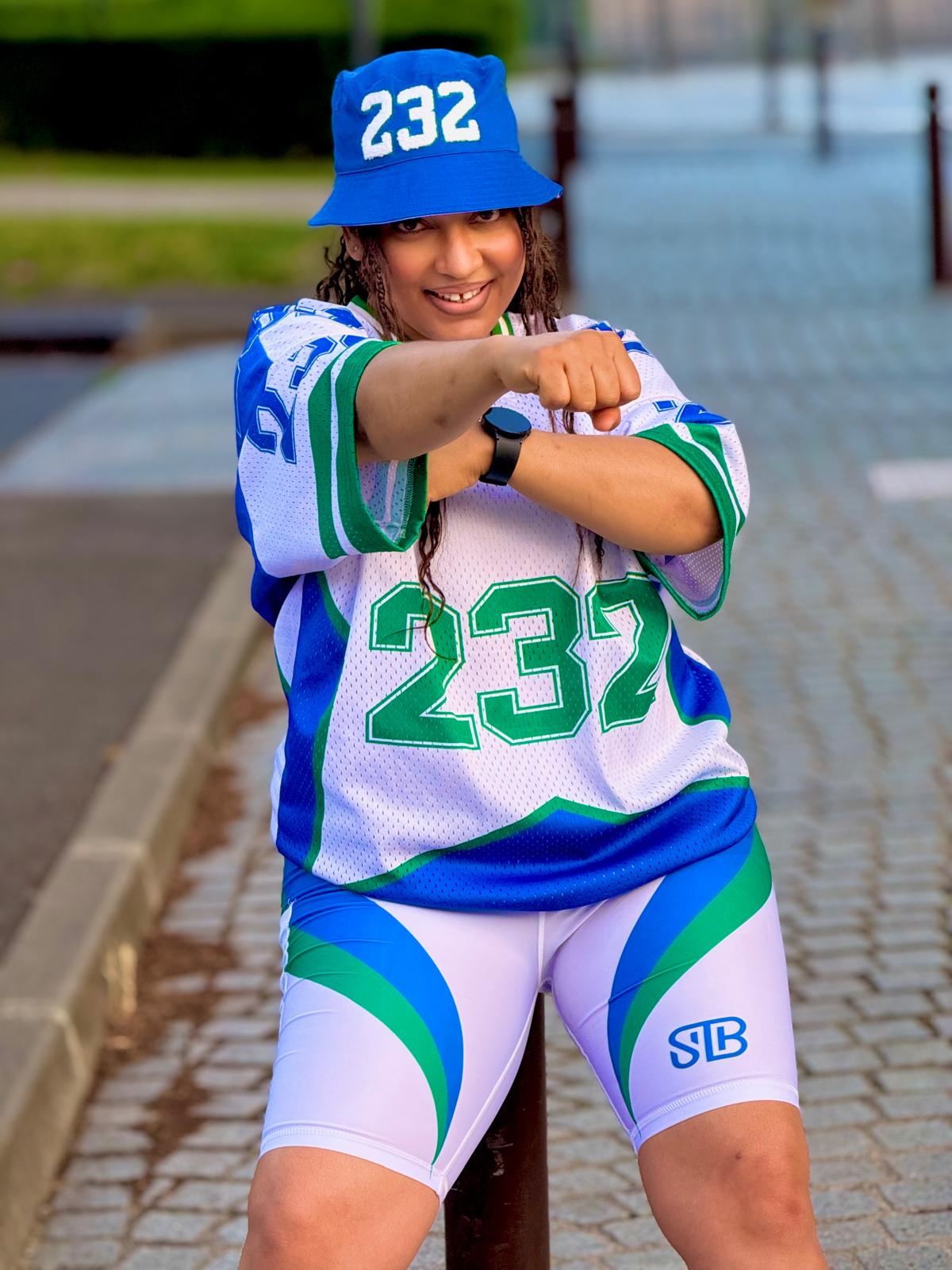 Person wearing a sports uniform with number 232 on a paved area